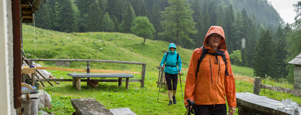 Hikers arriving in a rainstorm at Konjščica mountain cafe in Triglav National Park, Slovenia.